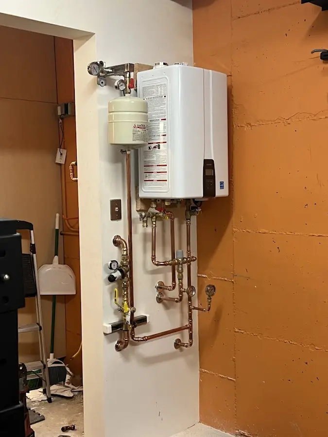 Plumbing technician inspecting water heater connections in Lamar